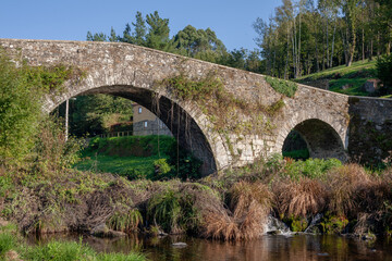 Fototapeta na wymiar Stone Roman Bridge Over Stream in Spanish Countryside