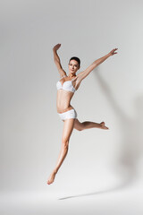 Fototapeta na wymiar beautiful jumping woman in white underwear