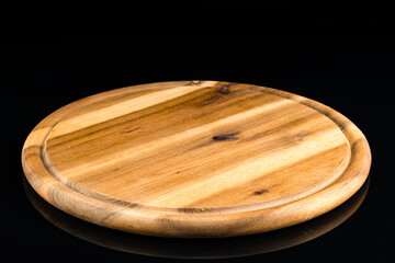 wooden round Board for serving on an empty black background