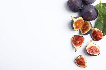 Delicious ripe figs with green leaf on white background, top view