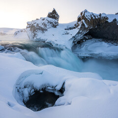 Geitafoss waterfall early morning in winter. Fresh snow on ground. North Iceland.