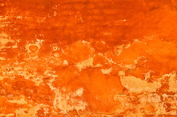 bright and vibrant orange coloured finery, plastering part of a wall, old and vintage, weathered