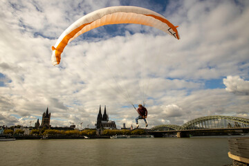 Man flying paraglider above Rhine River, Cologne - Germany