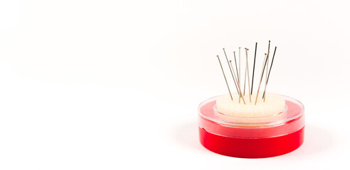 Red pack of tailor pins. Needle storage box with foam rubber pincushion. Sewing tool banner isolated on white background with copy space