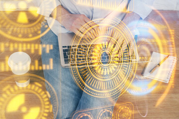 Technology theme hologram with man working on computer on background. High tech concept. Multi exposure.