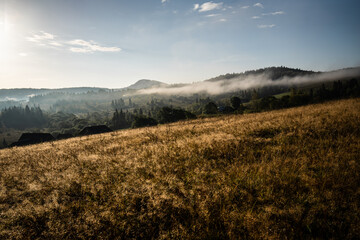 Obraz premium Autumn mountain village scenery. Clouds rising from Carpathian Mountains, Ukraine.