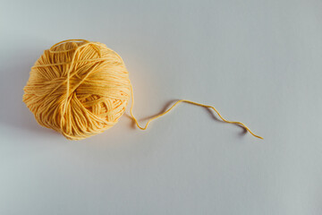 Ovillo de algod&oacute;n de color amarillo con fondo blanco 