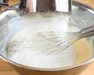 The flour falls into the bowl. Add the ingredient to the dough