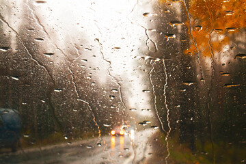 photograph of the road, through the windshield of a car, raindrops on the glass. Golden autumn, track landscape.