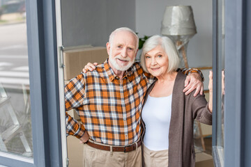 cheerful senior couple embracing each other in new house