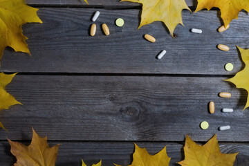 .Autumn foliage and medicines on wooden background