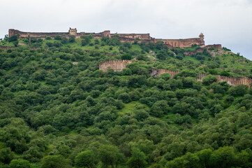 Fototapeta na wymiar Jaigarh Fort Palace on Aravalli hill range amidst in green trees. Jaigarh Fort is a UNESCO World Heritage site