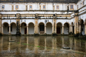 Naklejka premium Wet Reflective Courtyard Bordered By Cloister. Templar Castle/Convent Of Christ, Tomar, Portugal.