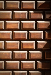 Close-up of an old brown wooden door with embossed rectangular shapes, full frame. Trentino Alto Adige, Italy, Europe.
