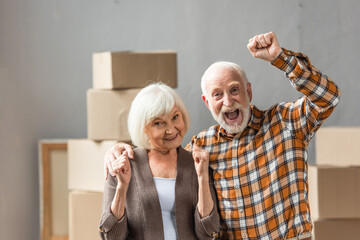 excited senior couple with fists up showing hooray sign, moving concept