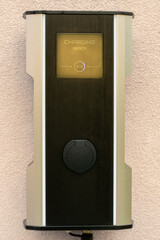 Electric car charger on the wall with writing CHARGING READY and covered socket