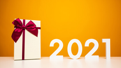 Merry christmas and Happy new year 2021 mockup on white table and yellow background with present gift box. Celebrate with new year  template and blank space background for advertise.