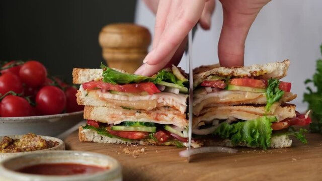 Club sandwich with bacon, lettuce, tomato and cheese on wooden board