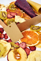 Scattered dried fruits and fruit pastille in open craft paper box