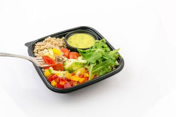 Salad with tuna, tomatoes, pepper, rocket, cucumber, sauce and fork
