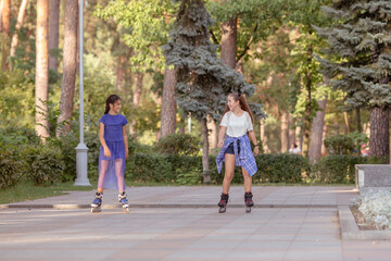 Obraz premium Girl rollerblading with her friend outdoors