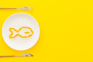 Omega fish oil supplement on plate from above