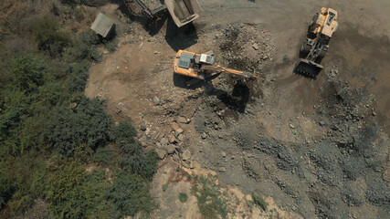 Processing of natural resources. Topview of yellow excavators picking up soil and stones.