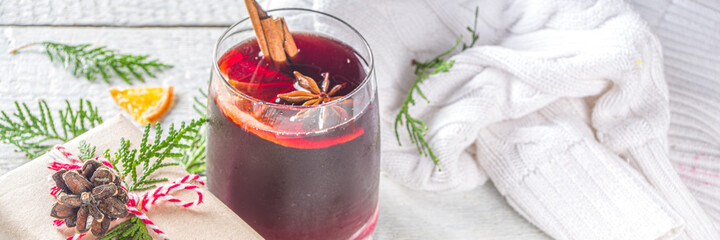 Festive Composition with Paper Craft Gift Box and Mulled Wine Glass, on wooden table with Christmas Fir Tree. Happy New Year and Christmas Greeting Card background advent