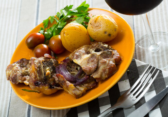Baked lamb leg chops served with sauteed potatoes, fresh tomatoes and greens..