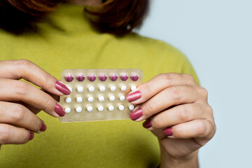 closeup female hand holding birth control pill