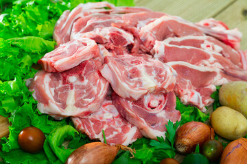 Raw lamb and vegetables assortment on natural wooden desk, cooking ingredients