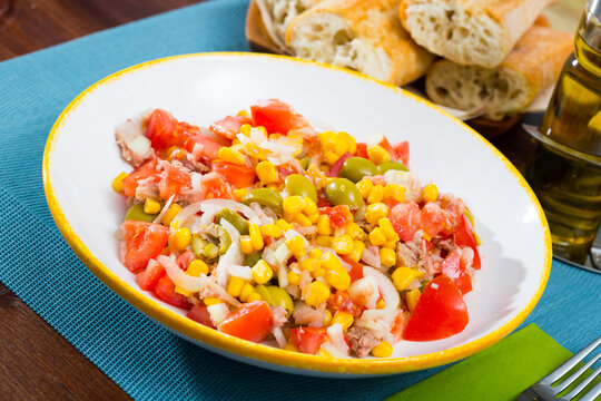 Appetizing salad with corn, olives and canned tuna. High quality photo