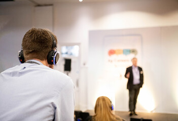 Fototapeta na wymiar Delegates Wearing Headphones At A Business Conference Meeting