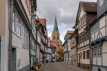 Medieval town narrow street with historical buildings and church bell tower in Lower Saxony