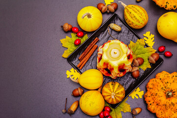 Autumn composition for Thanksgiving or Halloween with burning candle, pumpkins, acorns and fall leaves