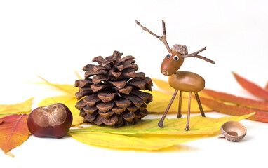 Autumn leaves, pine cone, horse chestnut and acorn deer figure.