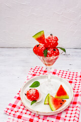 Sweet watermelon ice cream with coconut flakes and fresh basil leaves