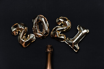 2021 golden foil balloons numbers, champagne, stars confetti, ribbons and bokeh. Top horizontal view copy space new year and holiday concept