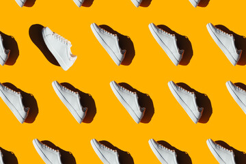 A pattern of white sneakers on an orange background.