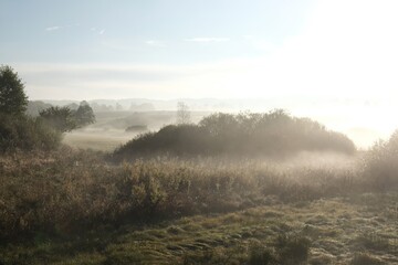 Beautiful autumn moody landscape - fields and meadows shrouded in mist in the morning.