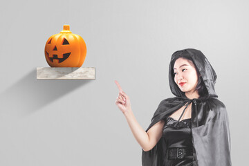 Asian witch woman with a cloak pointing something with jack-o-lantern