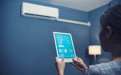 Smart home modern technology Asian girl sitting living room using tablet controlling remote system navigating adjusting functions light temperature and security setting, UI hologram screen display