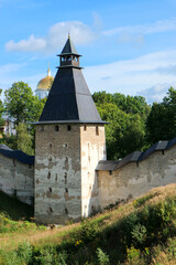 view to the Tower of the Upper Grids at the bottom of the ravine in Pskov-Pechory Dormition Monastery in Pechory, Pskov region, Russia under blue sky
