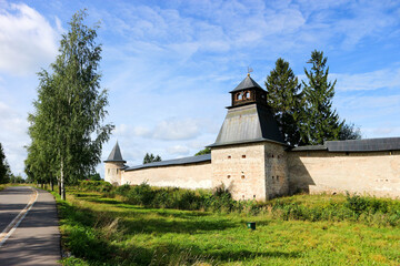 Fototapeta premium Beautiful summer panoramic view to the fortress wall and tower of Pskov-Pechory Dormition Monastery in Pechory, Pskov region, Russia under blue sky
