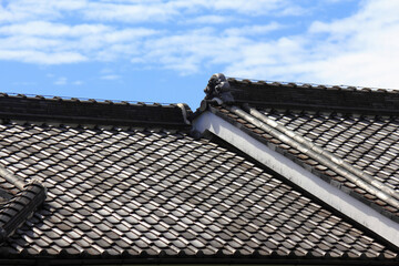 民家の屋根瓦と青空