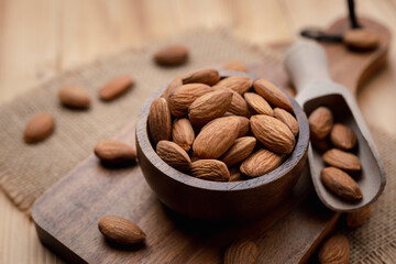 Almonds In Bowl on wood table background with copy space.