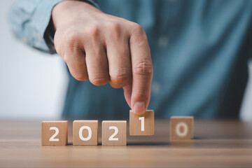 male hand hand putting wood cube for 2021 years. creative background for the new year. happy new years 2021 concept