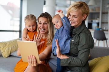 Young modern cheerful family talking through video-chat