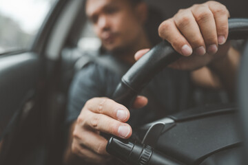 Car driver man close up is hands on  Car steering wheel While the turn signal is being turned on.