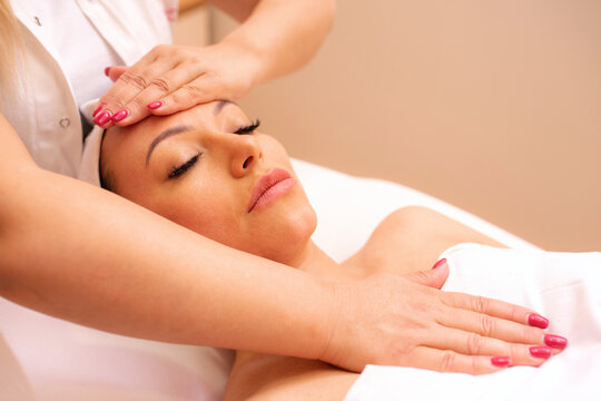 Masseuse massaging her clients face